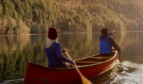 two people paddling sunset