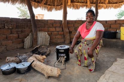 woman in zambia using an improved cookstove