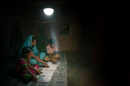 indian family sitting under solar lamp reading