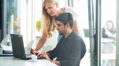 man and woman looking at computer