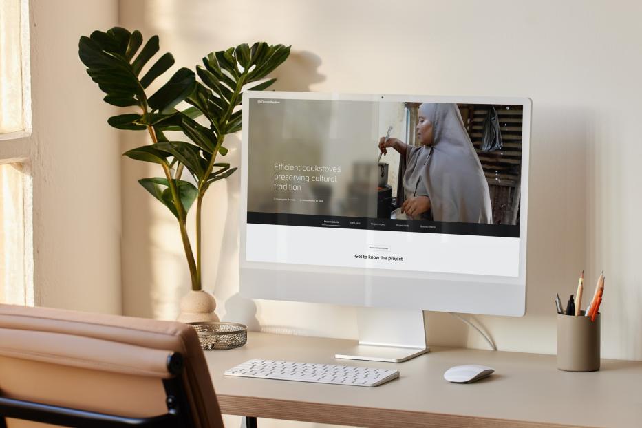 Schreibtisch mit Bildschirm neben einer Pflanze